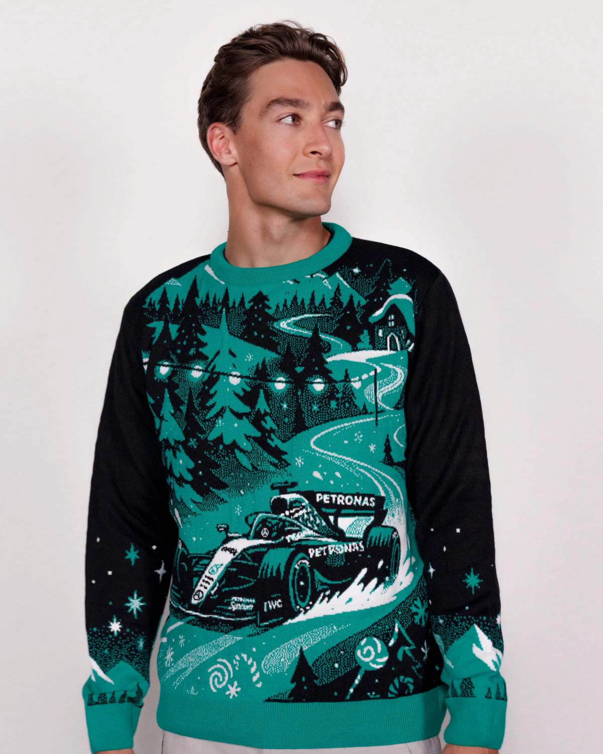 Man in a teal knitted Christmas jumper with a racing car motif